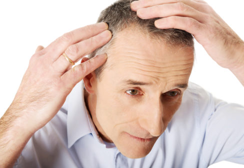 above-view-of-a-man-examining-his-hair